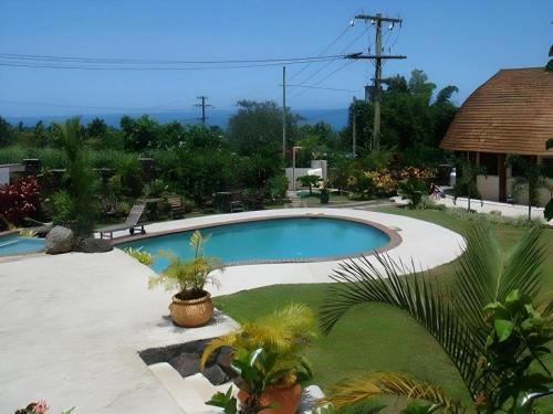 a swimming pool in a yard with plants at Le Manumea Hotel in Apia