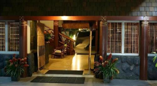 an entrance to a building with plants in theoyer at Le Manumea Hotel in Apia