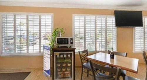 a dining room with a table and chairs and windows at Best Western Hanford Inn in Hanford