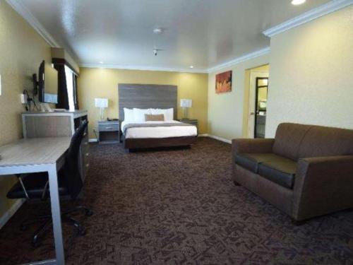 a large hotel room with a bed and a couch at Best Western Hanford Inn in Hanford