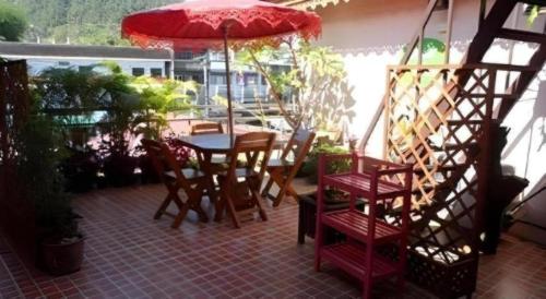 a patio with a table and chairs and an umbrella at Ngamta Hotel in Mae Hong Son