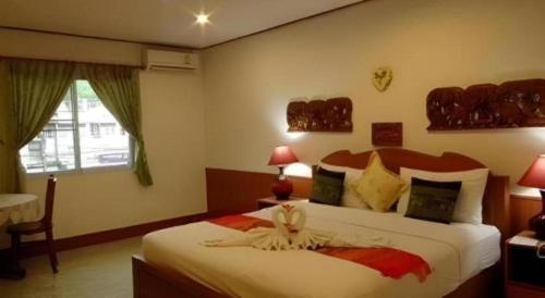 a bedroom with a large bed and a window at Ngamta Hotel in Mae Hong Son