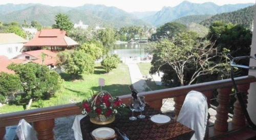 a table on a balcony with a view of a river at Ngamta Hotel in Mae Hong Son