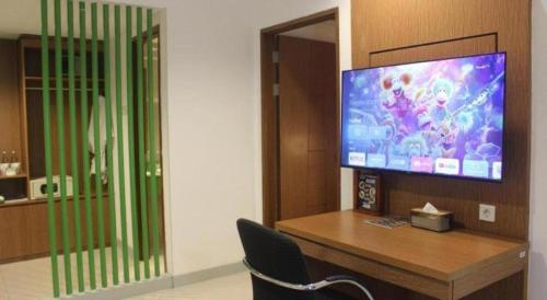 a room with a flat screen tv on a desk at Pomelotel Patra Kuningan Jakarta in Jakarta