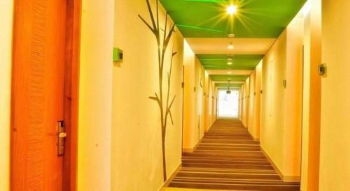a hallway with orange and green ceilings and a plant at Pomelotel Patra Kuningan Jakarta in Jakarta