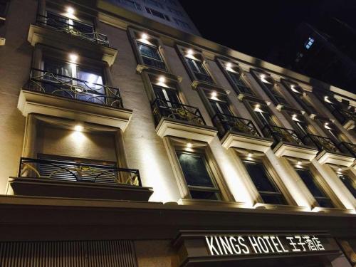 a tall building with balconies and lights on it at King's Hotel in Hong Kong
