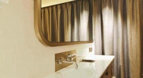 a bathroom with a sink and a mirror at King's Hotel in Hong Kong