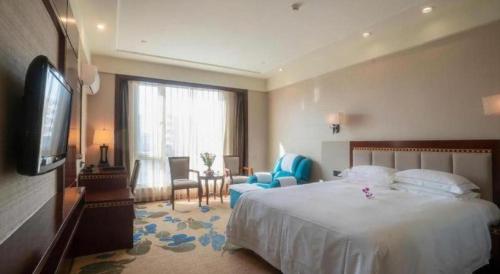 a hotel room with a bed and a television at Dong Cheng Hotel in Shunde