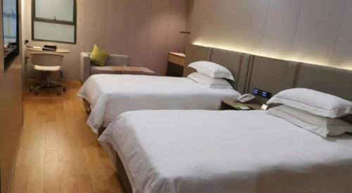 a hotel room with two beds and a phone in it at Dong Cheng Hotel in Shunde