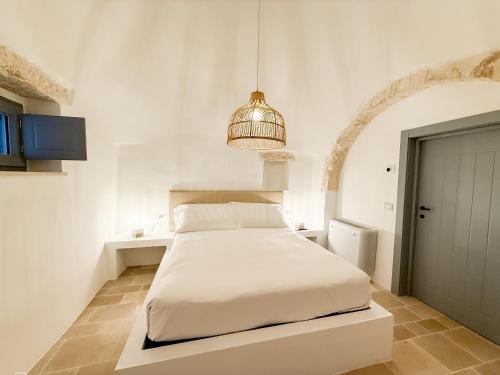 a white bedroom with a bed in a room at Borgo Cucumo by MONHOLIDAY in Castellana Grotte