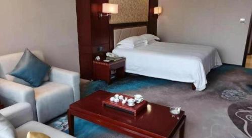 a hotel room with a bed and a coffee table at Dong Cheng Hotel in Shunde