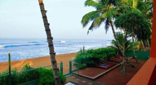 a view of a beach with palm trees and the ocean at OYO 246 Roy Villa Beach Hotel in Beruwala