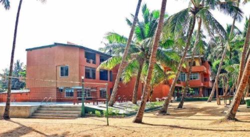 a building with palm trees in front of it at OYO 246 Roy Villa Beach Hotel in Beruwala