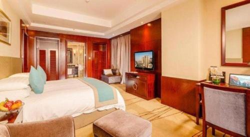 a hotel room with a bed and a television at Gaosu New Century Hotel International Anhui in Hefei