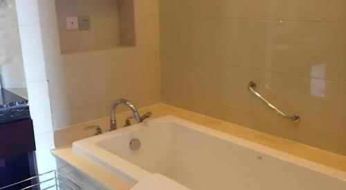 a bath tub with a faucet in a bathroom at Gaosu New Century Hotel International Anhui in Hefei