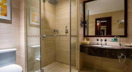 a bathroom with a glass shower and a sink at Northwest Petroleum Hotel in Ürümqi