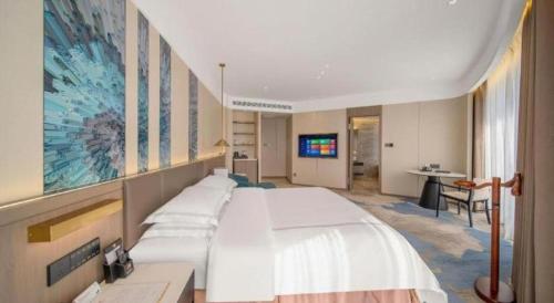 a bedroom with a large white bed in a room at Northwest Petroleum Hotel in Ürümqi