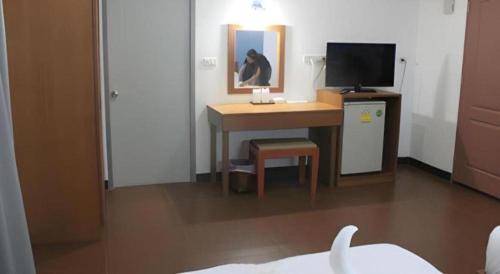 a room with a desk with a computer and a tv at Urban House 195 in Chiang Mai