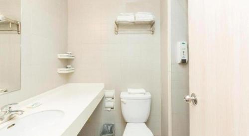 a white bathroom with a toilet and a sink at Jinjiang Inn Changchun Xi An Avenue Branch in Changchun