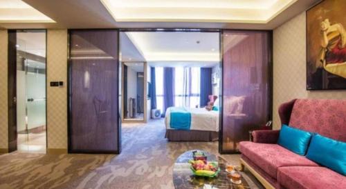 a living room with a couch and a bed at Shijiazhuang Ximeijin Continental Hotel in Shijiazhuang