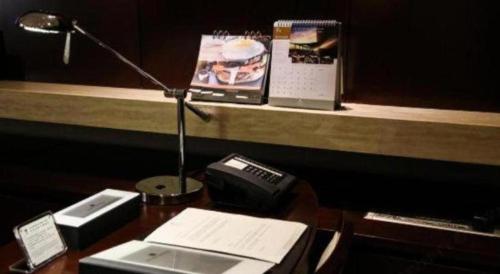 a desk with a lamp and a telephone on it at Xi'an Airport Hotel in Xi'an