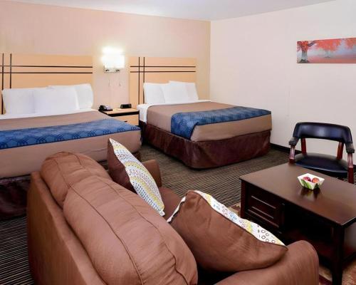 a hotel room with two beds and a couch at Econo Lodge Rochester I-90 & I-390 in Rochester