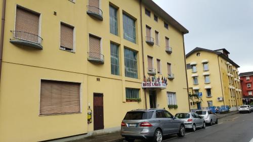a yellow building with cars parked in front of it at Hotel San Marco BB in Boario Terme