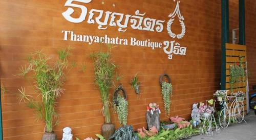 a sign on a wall with plants on it at Thanyachatra Boutique. in Phetchaburi