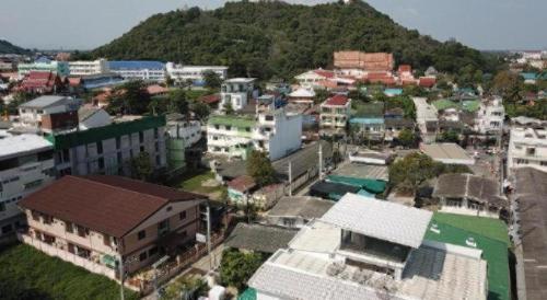 an aerial view of a city with buildings and a mountain at Thanyachatra Boutique. in Phetchaburi