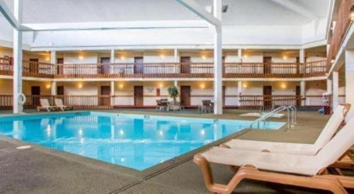 a large swimming pool in a hotel with two chairs at Econo Lodge Inn & Suites in Stevens Point