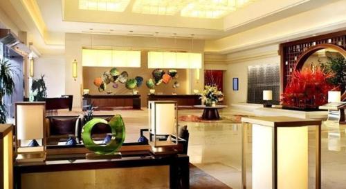 a lobby of a hotel with a green chair at Quanzhou Guest House Hotel in Quanzhou