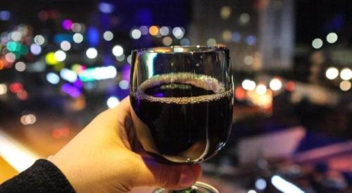 a person holding a glass of red wine at Check Inn Hotel in Jeju