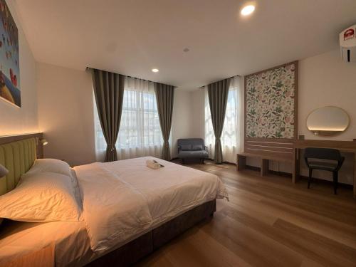 a bedroom with a bed and a desk in it at Pepper Inn in Sibu