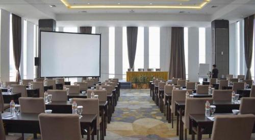 a large room with tables and chairs and a projection screen at Bogor Valley Hotel in Bogor