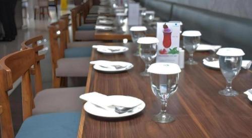 a long wooden table with plates and glasses on it at Bogor Valley Hotel in Bogor