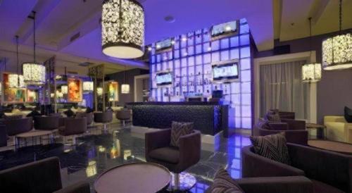 a lobby with a bar with chairs and lights at Brits Hotel Karawang in Karawang