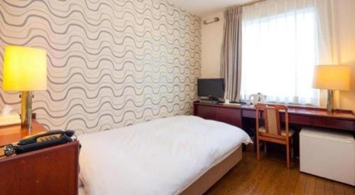 Postel nebo postele na pokoji v ubytování Fukuyama Terminal Hotel