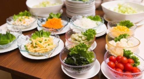 a table topped with bowls of food on plates at Daini Fuji Hotel in Nagoya