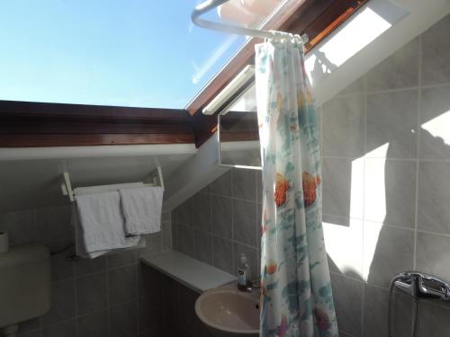 a bathroom with a shower curtain and a sink at Villa Ana in Bol