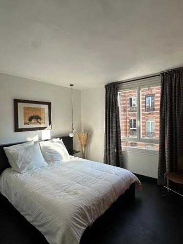 een slaapkamer met een groot bed en een raam bij design apartment in Parijs