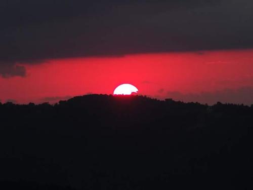 a red sun setting on top of a hill at Zirve Dağ Evi in Kocaeli