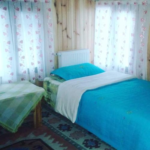 a bedroom with two beds and a window with curtains at Zirve Dağ Evi in Kocaeli