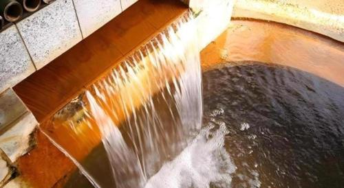 an overhead view of a waterfall with water pouring down at Hotel Myoken Tanaka Kaikan in Kirishima