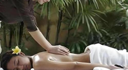 a woman getting a back massage from a massage therapist at Hotel Myoken Tanaka Kaikan in Kirishima