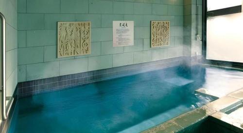 a swimming pool with blue water in a room at Sakuraan Kawaguchiko Hotel in Fujikawaguchiko