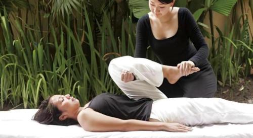 a woman is putting a woman on a pilates at Sakuraan Kawaguchiko Hotel in Fujikawaguchiko