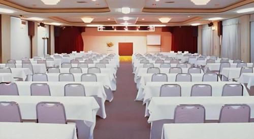 a large room with white tables and chairs at Hotel Shofuen in Toyohashi