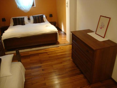 - une chambre avec un lit et une commode en bois dans l'établissement Apartment Kaucic, à Banjole