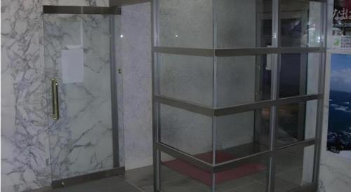 a glass shelf in a bathroom with a shower at Albert Hotel in Akita