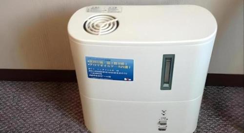 a white cooler sitting on the floor next to a wall at Alpha Hotel Tokushima in Tokushima